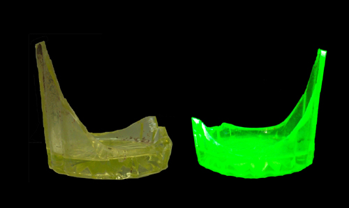 Image of Vaseline Glass. On left: yellow tumbler base and body fragment. One right: tumbler under black light.
